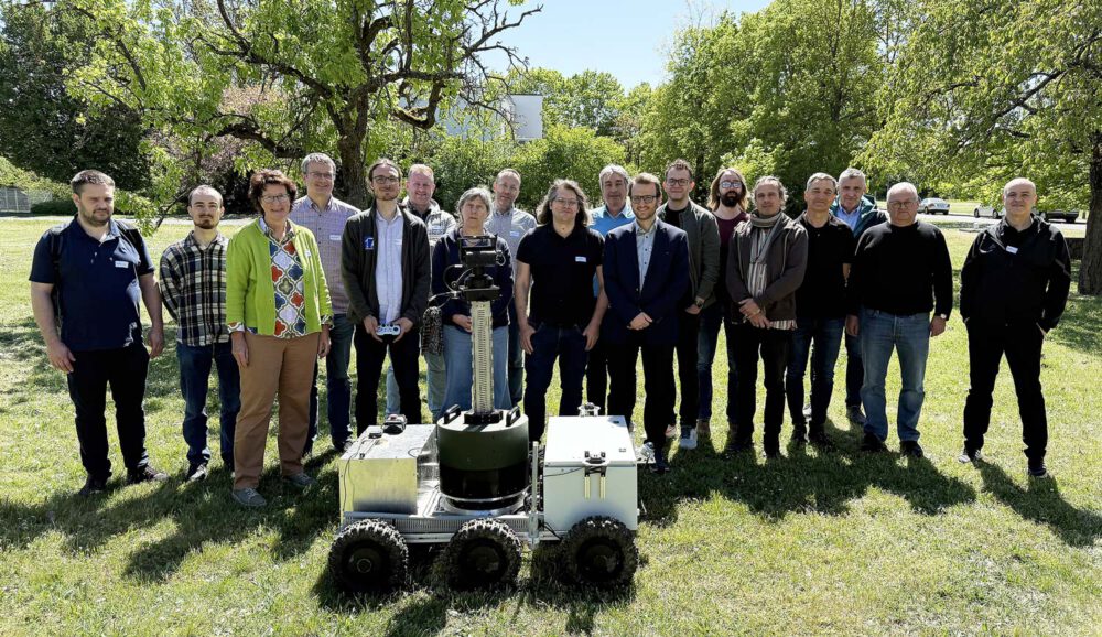 Gruppenbild mit Roboter vom Netzwerktreffen an der Julius-Maximilians-Universität Würzburg am 29.04.2026